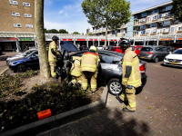 Automobilist rijdt plantsoen in bij winkelcentrum