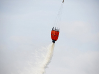 Blushelikopter van Defensie oefent met Fire bucket bij brand op Duivelseiland Dordrecht