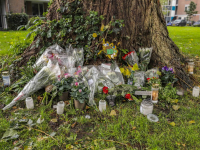 Familie en vrienden leggen bloemen bij boom in Stadspolders Dordrecht