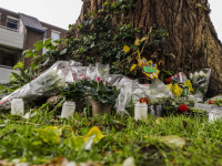 Familie en vrienden leggen bloemen bij boom in Stadspolders Dordrecht