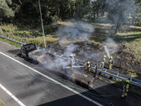 Grasmaaier op oplegger brandt uit langs A16
