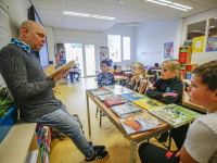 Jozua Douglas leest voor in klassen JFK zuidendijk Dordrecht