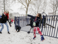 Kinderen spelen met juf in de sneeuw school Keerkring Dordrecht