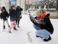 Kinderen spelen met juf in de sneeuw school Keerkring Dordrecht