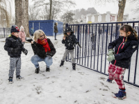 Kinderen spelen met juf in de sneeuw school Keerkring Dordrecht