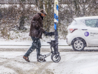 Oudere man met rollator door de sneeuw de Raadsingel Dordrecht