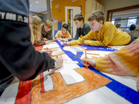 Groep 8 Beatrixschool maken spandoek voor het ISU World Cup shorttrack in Dordrecht