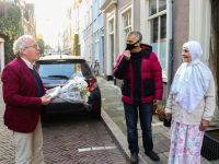 Frits Baarda reikt boek uit aan oudste bewoonter Hoge Nieuwstraat Dordrecht