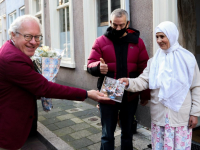 Frits Baarda reikt boek uit aan oudste bewoonter Hoge Nieuwstraat Dordrecht