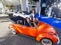 Leen en Reinier de Koning bij een oranje Kever Ames 75 jaar Dordrecht